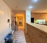 Der Flur mit einem Boden in Holzoptik führt zur Küche in der 3-Zimmer-Wohnung.