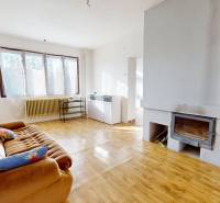 Wohnbereich mit Sofa, Kamin und Holzboden in einem Einfamilienhaus.