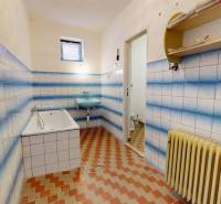 Ein Badezimmer in einem Einfamilienhaus mit blau-weißen Fliesen und einer Badewanne.