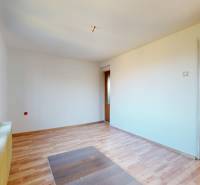 Ein Zimmer in einem Einfamilienhaus mit einem Holzboden und großen Fenstern.