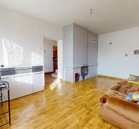 Wohnzimmer eines Einfamilienhauses mit einem Sofa und einem Boden in Holzoptik.