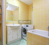 Badezimmer mit Dusche, Badewanne und Waschmaschine in einer 2-Zimmer-Wohnung mit Fliesen.