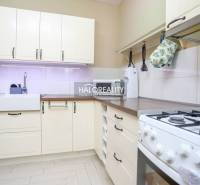 Küche in einer 2-Zimmer-Wohnung mit rustikalen Schränken und einem Gasherd, helles Design.