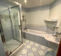 Badezimmer in einer 3-Zimmer-Wohnung mit Dusche, Badewanne und hellen Fliesen.