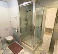 Badezimmer in einer 3-Zimmer-Wohnung mit Waschmaschine, Duschkabine und weißen Möbeln.