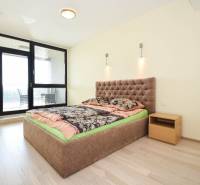 Schlafzimmer in einer 3-Zimmer-Wohnung mit einem bequemen Bett und einem Boden in Holzoptik.