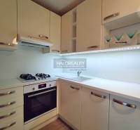 Küche in einer 2-Zimmer-Wohnung mit weißen Schränken, Gasherd und Stauraum.