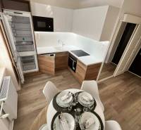 Küche in einer 2-Zimmer-Wohnung mit Holzboden und Esstisch.