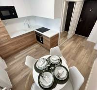 Küche in einer 2-Zimmer-Wohnung mit Holzboden und Esstisch.