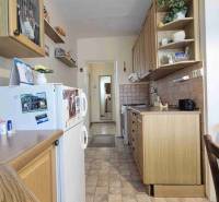 Küche in einer 2-Zimmer-Wohnung mit Holzdekor und weißen Wänden.