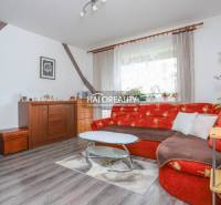 Wohnzimmer in einer 3-Zimmer-Wohnung mit rotem Sofa und Holzboden.