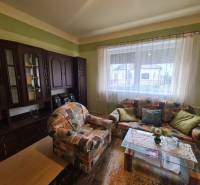 Wohnzimmer eines Einfamilienhauses mit einem bunten Sofa und einer dunklen Wohnwand.