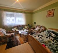 Wohnzimmer in einem Einfamilienhaus mit Sofa, Teppichen und einem dekorativen Bild an der Wand.