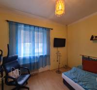 Ein Zimmer in einem Einfamilienhaus mit Fitnessgeräten, einem Sessel und einem Fernseher.