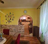 Esszimmer in einem Einfamilienhaus mit einem Bogenübergang und einem Boden in Holzoptik.