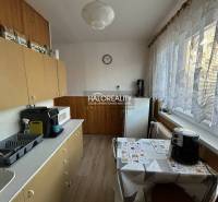 Küche in einer 2-Zimmer-Wohnung mit Geräten und langen Vorhängen am Fenster.