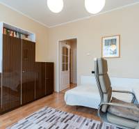 Ein Arbeitszimmer in einer Vierzimmerwohnung mit einem Holzboden und hellen Möbeln.