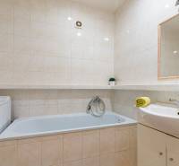 Badezimmer in einer 4-Zimmer-Wohnung mit Badewanne, Waschmaschine und Waschbecken mit Handtuch.