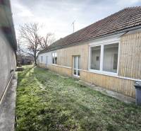 Ein Einfamilienhaus in Lúčnica nad Žitavou mit Holzverkleidung und Garten.