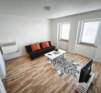 Wohnzimmer in einem Einfamilienhaus mit Sofa, Tisch und Holzboden.