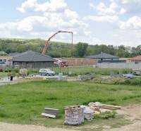 Grundstücke - Wohnen in Modrovka; man sieht im Bau befindliche Häuser und Baumaterial.