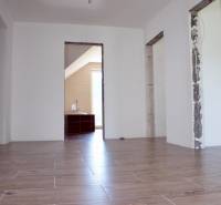 Innenraum eines Einfamilienhauses mit Holzboden und unbedeckten Bauöffnungen.