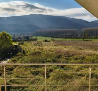 Blick von einem Einfamilienhaus in Buková auf die Landschaft mit Bäumen und einem Feld.