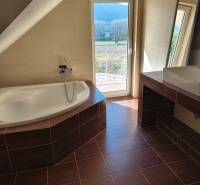 Badezimmer eines Einfamilienhauses mit Badewanne und Boden in Holzoptik.