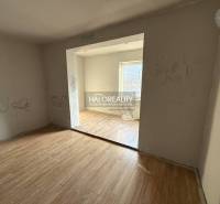 Izba v rodinnom dome s podlahou s dreveným dekorom a nápismi na stenách.