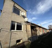 Ein Einfamilienhaus in Chynorany mit Satelliten und Garten, nebenan weitere Häuser.