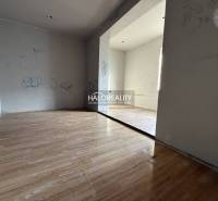 Ein Zimmer in einem Einfamilienhaus mit einem Holzboden und schlichten Wänden.