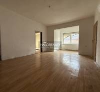 Innenraum eines Einfamilienhauses mit Holzboden und großem Fenster.