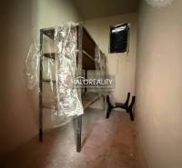 Ein enger Lagerraum mit Regalen und Plastikverpackung in einem Einfamilienhaus.