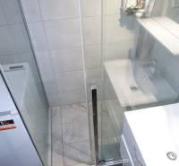 Badezimmer mit Duschkabine und Waschmaschine in einer 3-Zimmer-Wohnung.