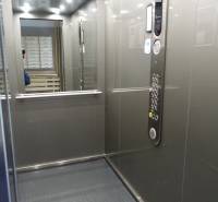 Der Innenraum des Aufzugs mit Bedienfeld und Spiegel in einer 3-Zimmer-Wohnung.