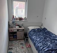 Kinderzimmer mit Bett, Fenster und Teppich in einer 4-Zimmer-Wohnung.