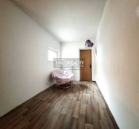 Ein Raum in einem Einfamilienhaus mit einem Sessel und einem Boden mit Holzdekor.