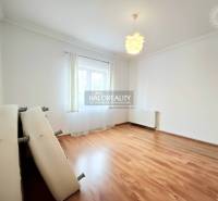 Ein geräumiges Zimmer mit Holzboden und heller Ausstattung in einem Einfamilienhaus.