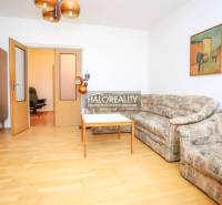 Wohnzimmer einer 3-Zimmer-Wohnung mit Sofa, Tisch und Holzboden.