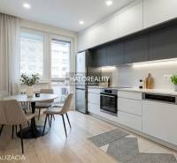 Essbereich mit rundem Tisch und Küche mit Küchenzeile in einer 3-Zimmer-Wohnung.