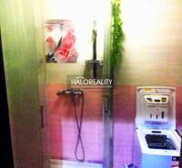 Badezimmer in einer 2-Zimmer-Wohnung mit Dusche und Waschmaschine, farblich in Rosa gehalten.