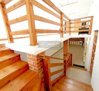 Holztreppen und Geländer in einem Einfamilienhaus mit einem Ziegelstein-Detail an der Wand.