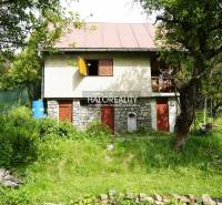 Ein gemütliches Häuschen, umgeben von üppigem Grün und Bäumen in einer natürlichen Umgebung.