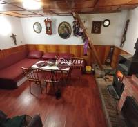 Rustikale Hütte, Holzbalkendecke, Kamin, bequeme Sitzgarnitur, traditionelles Interieur, angenehme Atmosphäre.