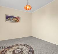 Ein Zimmer in einem Einfamilienhaus mit Teppich, Vorhang, Bild und einer Deckenleuchte.