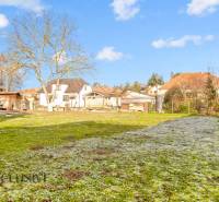 Der Garten beim Einfamilienhaus in der Nemečkovská-Straße in Prašice mit Bäumen und Rasen.