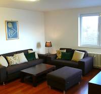 Wohnzimmer in einer 4-Zimmer-Wohnung mit Sofas, Fernseher und Holzboden.