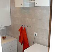 Badezimmer mit Waschmaschine und Stauraum in einer 4-Zimmer-Wohnung.