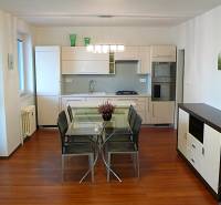 Küche einer 4-Zimmer-Wohnung mit Esstisch und Boden in Holzoptik.