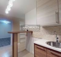 Küche einer 2-Zimmer-Wohnung mit Holzboden und Bartresen.